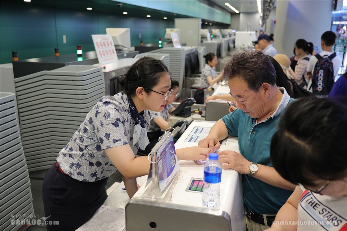 東航地面服務(wù)人員正在值機柜臺向旅客解釋航班情況。