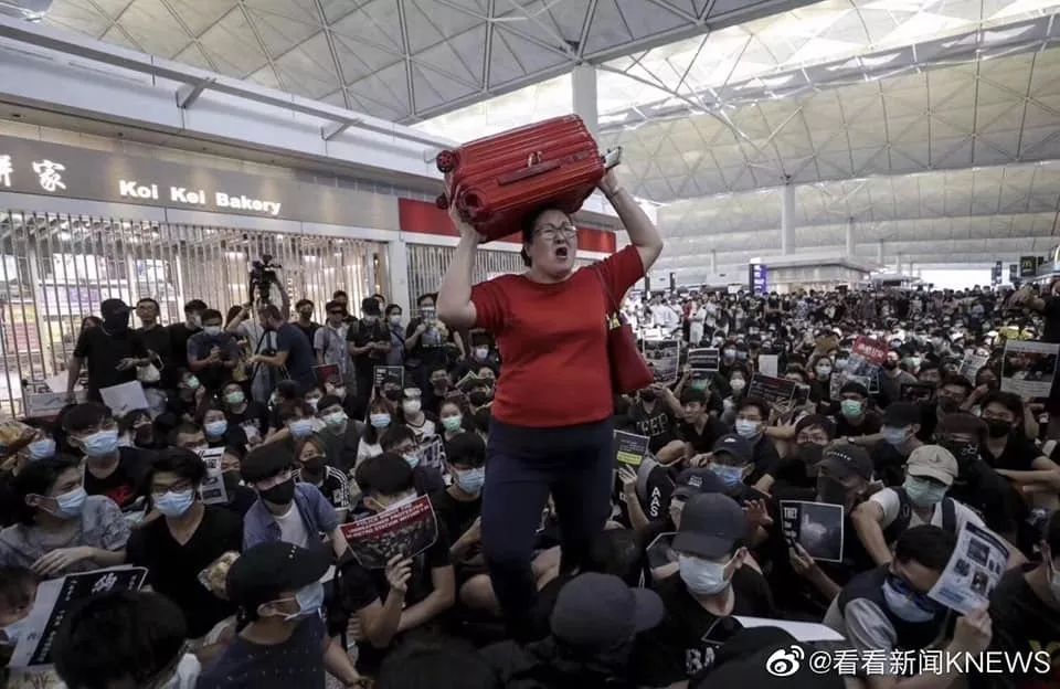 面對香港機(jī)場滿地示威者 新加坡紅衣女子沖了出去