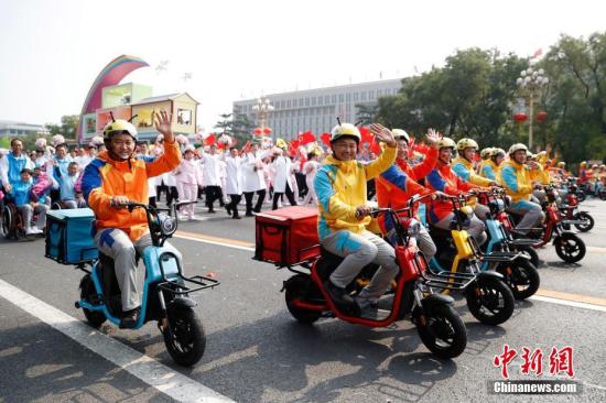 10月1日上午，慶祝中華人民共和國成立70周年大會(huì)在北京天安門廣場隆重舉行。圖為群眾游行中的“快遞小哥”。中新社記者 韓海丹 攝